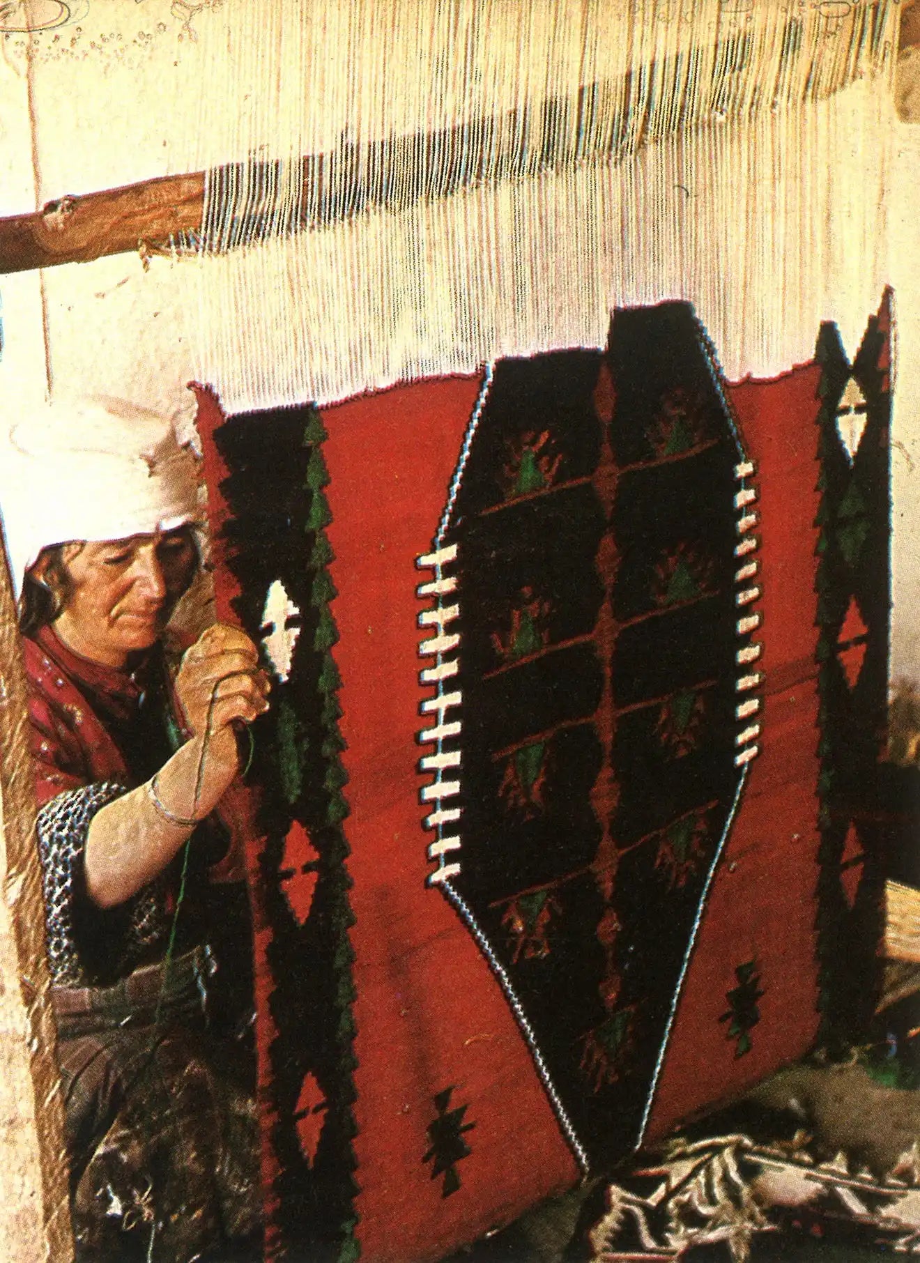 Handwoven red and black rug with geometric patterns.